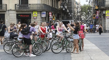 Grup de turistes visitant el centre de Barcelona. Turistes amb bicicleta